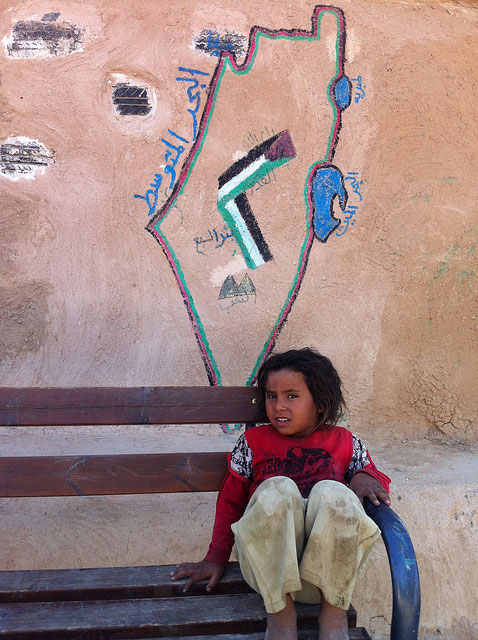 A Jahalin Bedouin girl in front of her mud and tyre school. IMAGE: dombook11, Flickr.