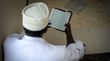 A delegate reads the Koran at an anti-extremism conference. (IMAGE: AMISOM Public Information, Flickr)