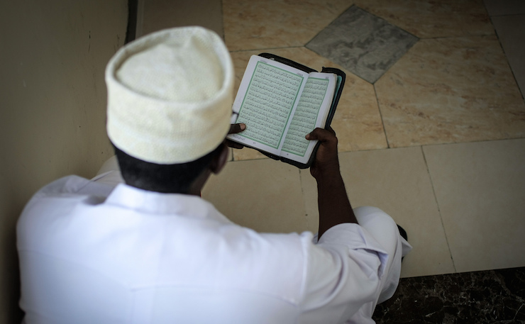 A delegate reads the Koran at an anti-extremism conference. (IMAGE: AMISOM Public Information, Flickr)