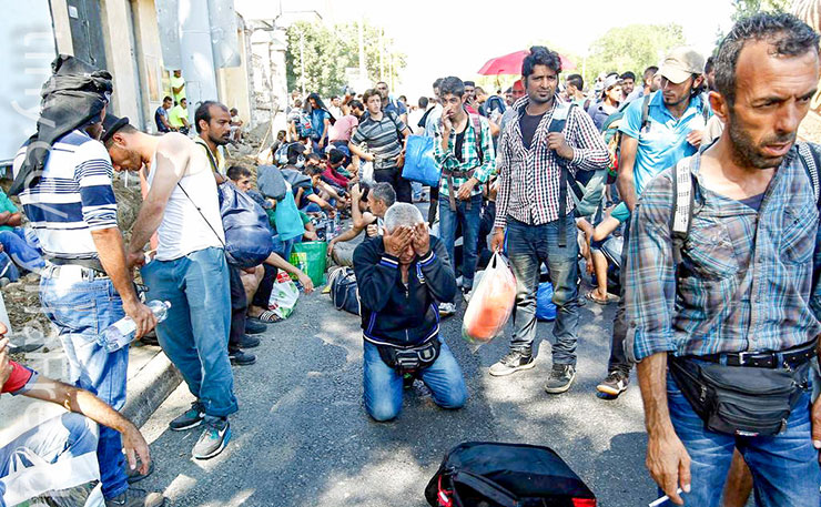 Syrian Refugees Refugees walk along Budaorsi Street on their way out of Budapest, Hungary. (IMAGE: Freedom House , Flickr)