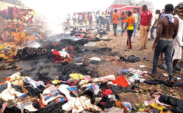 Rescuers and residents gather at the charred scene following a bomb blast at Terminus market in the central city of Jos on May 20, 2014. Twin car bombings on Tuesday killed at least 46 in central Nigeria in the latest in a series of deadly blasts that will stoke fears about security despite international help in the fight against Boko Haram Islamists. (IMAGE: Diariocritico de Venezuela, AFP PHOTO/STR, Flickr)