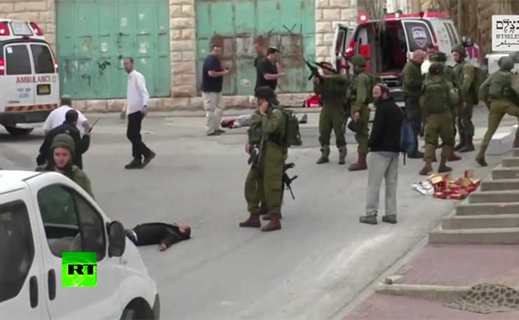 An Israeli soldier cocks his rifle, shortly before shooting dead an injured Palestinian man lying wounded in the streets of Hebron.