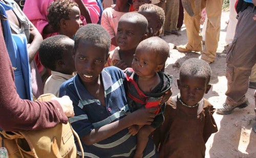 Children queue for food at a aid distribution centre in Mogadishu, Somalia, August 2011. (IMAGE: UK Department for International Development/ James Hooley, Flickr)