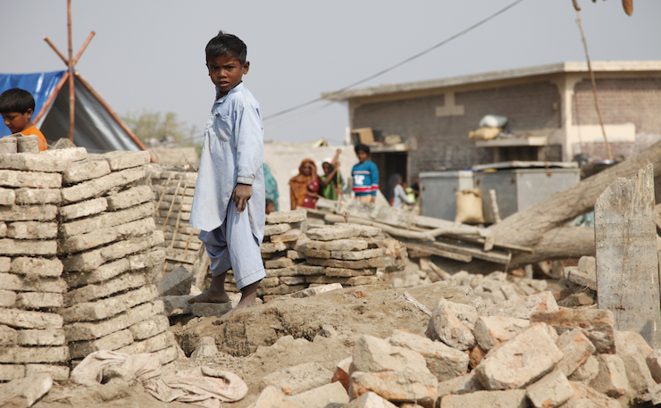 IMAGE: UK Department for International Development, Flickr. A child stands in rubble left by Pakistani floods.