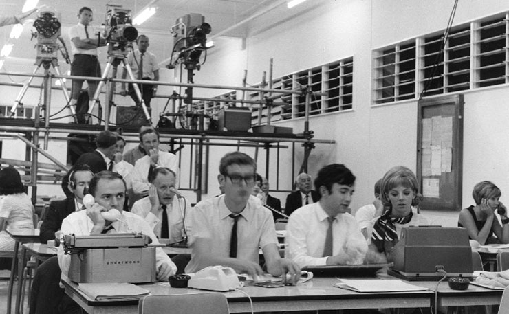 1969 Federal election coverage, in Brisbane. What an election night tally room can look like - the Brisbane scene at the Federal poll [1969]. At front row of desks L-R: F McKechnie (News), R Greening (News), A Maniaty (News) and Mrs Nona Shea (comptometrist). (IMAGE: ABC, Flickr)