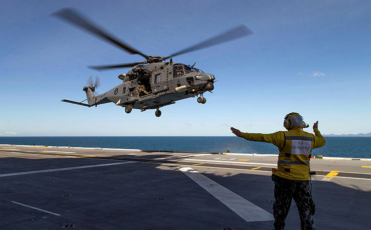 Leading Seaman Aviation Support Justin Prasad directs HMNZS Canterbury's NH90 helicopter to land on HMAS Canberra's flight deck during Exercise Talisman Sabre. (IMAGE: LSIS Helen Frank, Department of Defence)