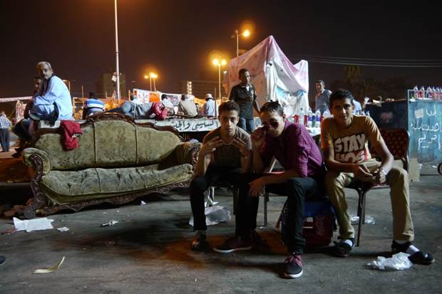 Boys pose on permanent 'square furniture' in Tahrir Square. Photo by Rachel Williamson.