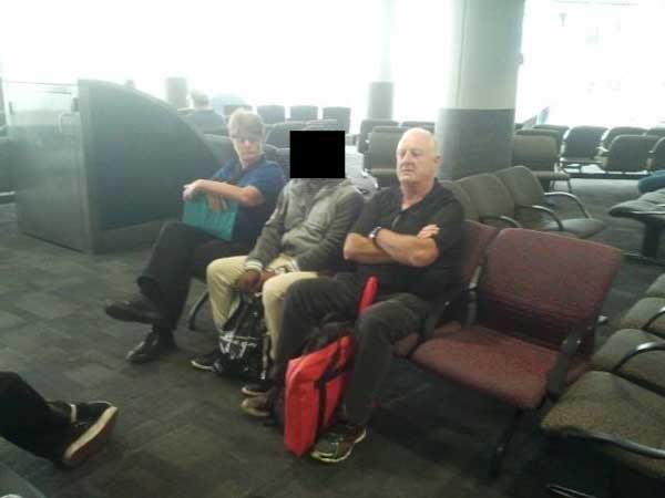 A Tamil asylum seeker waits with his escorts, for a flight to Darwin this morning.