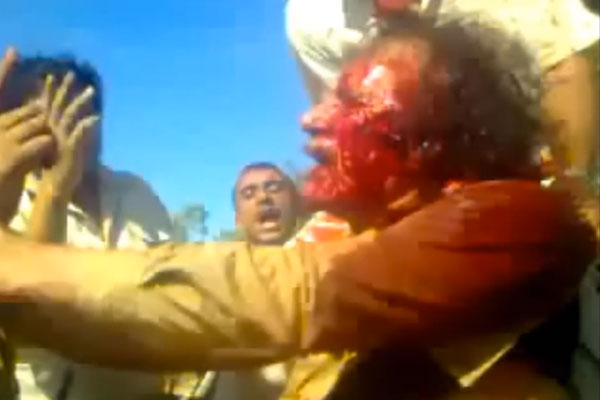 A screenshot from a video recording the last minutes of Muammar Gaddafi.