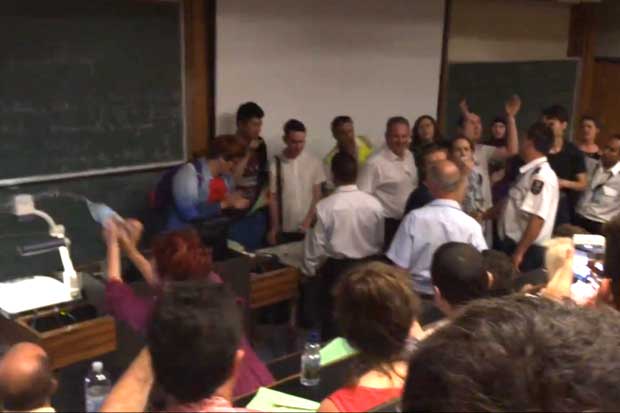 A still of the video, showing water being thrown on protestors by the 'red-haired woman' (in the bottom right of the photo).