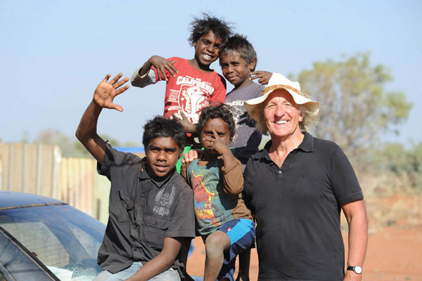 Journalist and film-maker John Pilger, pictured with children from Irrultja, a tiny homeland community on the edge of the Utopia region in Central Australia.