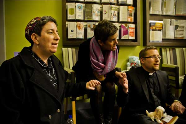Rabbi Shoshana Kaminksy (left) prays with protestors during a sit in at the Adelaide offices of federal MP Jamie Briggs last night.