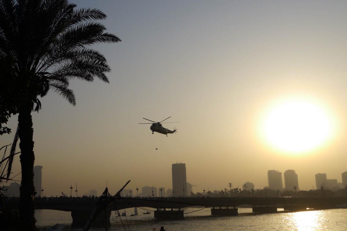 A helicopter drops Egyptian flags and Sisi propaganda over the crowds on Kasr el Nil bridge. Photo by Rachel Williamson