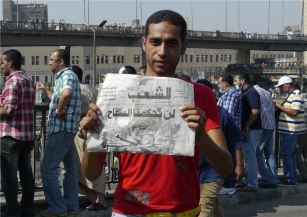 A protester in Cairo with a sign that reads: "we will not be ruled by killers" referring to General Sisi and the army. Photo by Rachel Williamson.